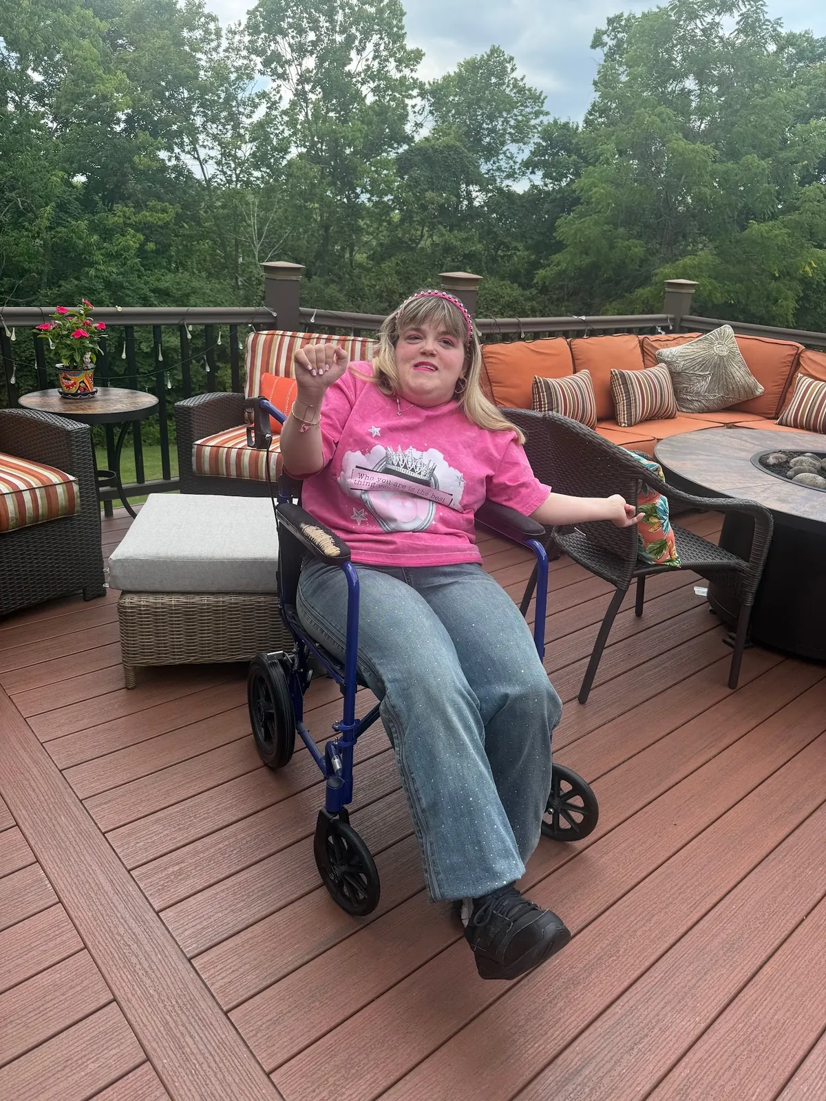 Marisa wearing Lady Fines' Pretty Iconic Adaptive Jeans with a pink graphic tee and a silver M necklace.